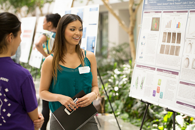 Students looking at poster presentations at the research symposium